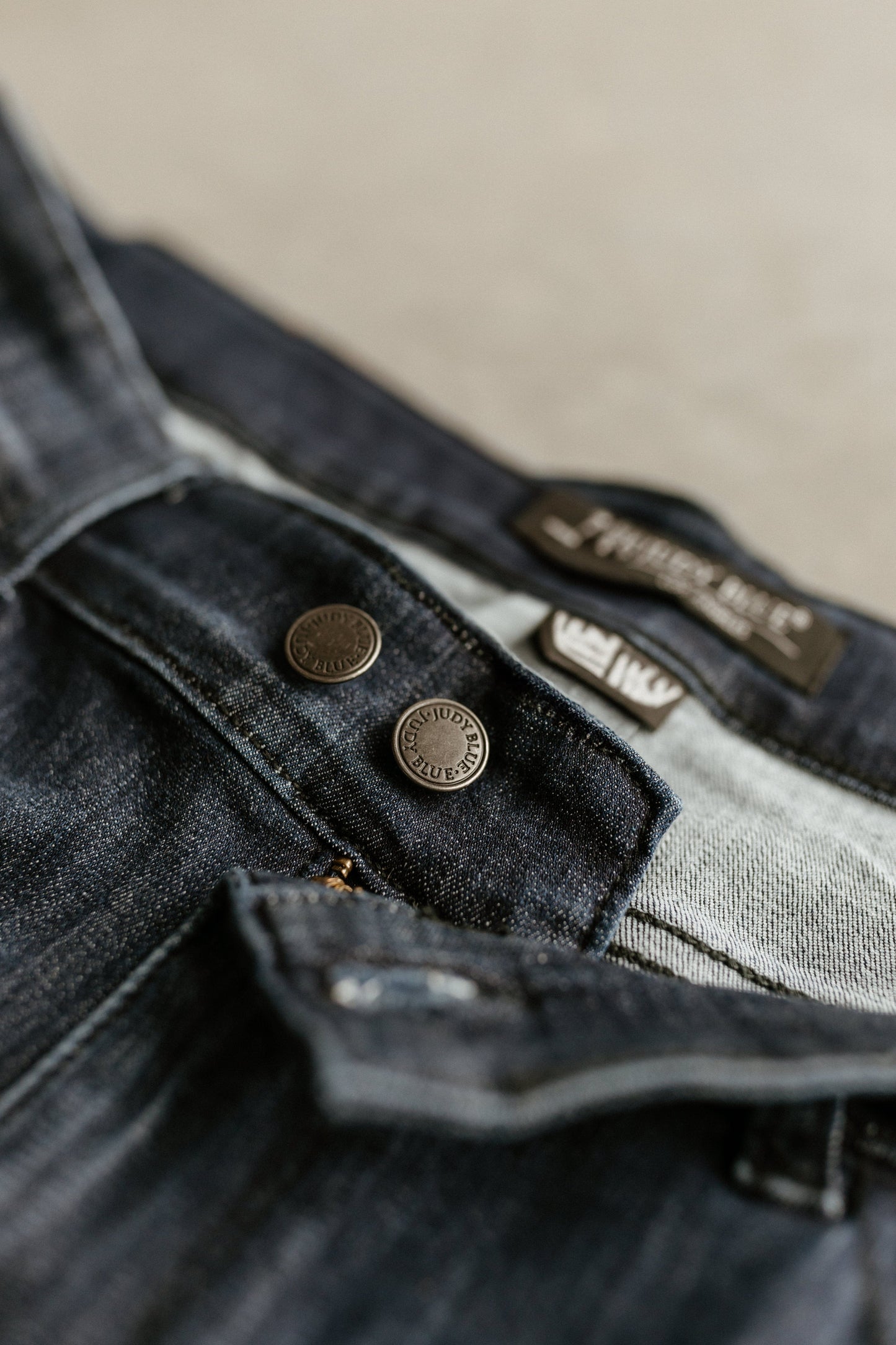 Close-up of Judy Blue dark wash mid-rise skinny jeans showcasing the waistband, button details, and label.