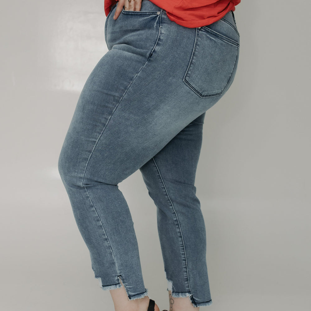 Person wearing blue jeans and a red top on a plain background
