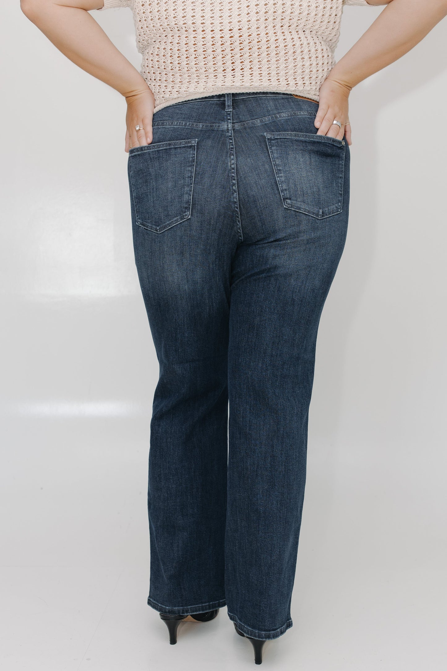 Person wearing blue jeans with a plain background