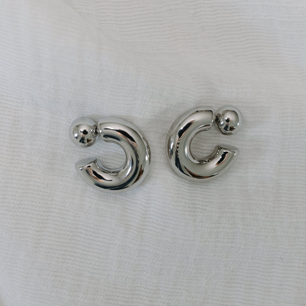 Silver moon-shaped earrings on a white background