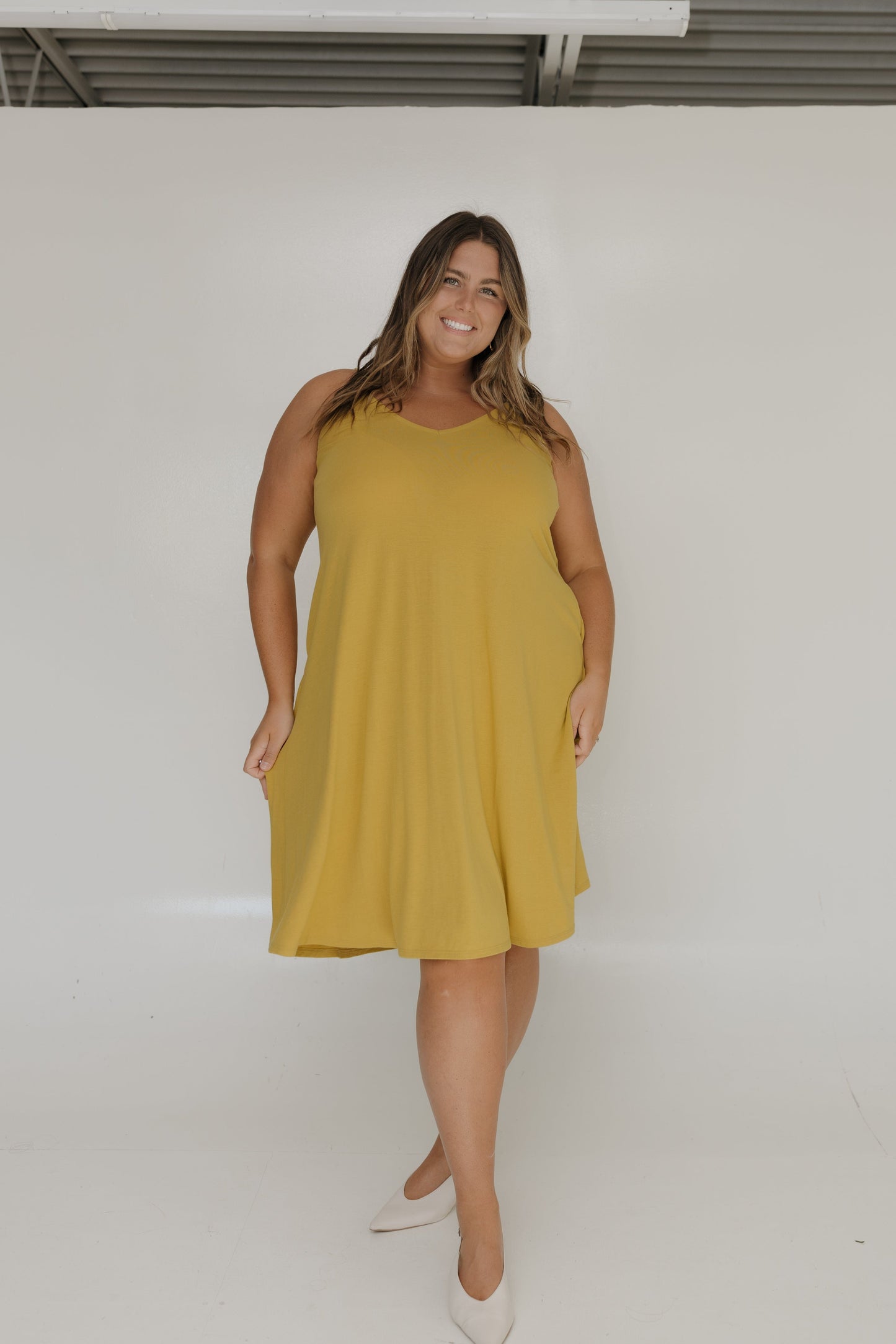 Woman wearing a yellow dress against a white background