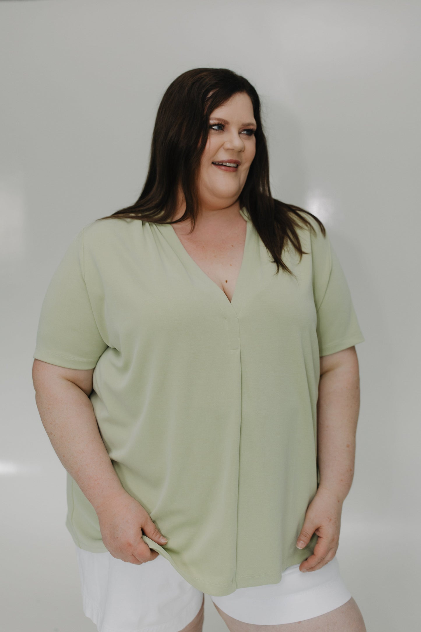 Woman wearing a light green top against a plain background