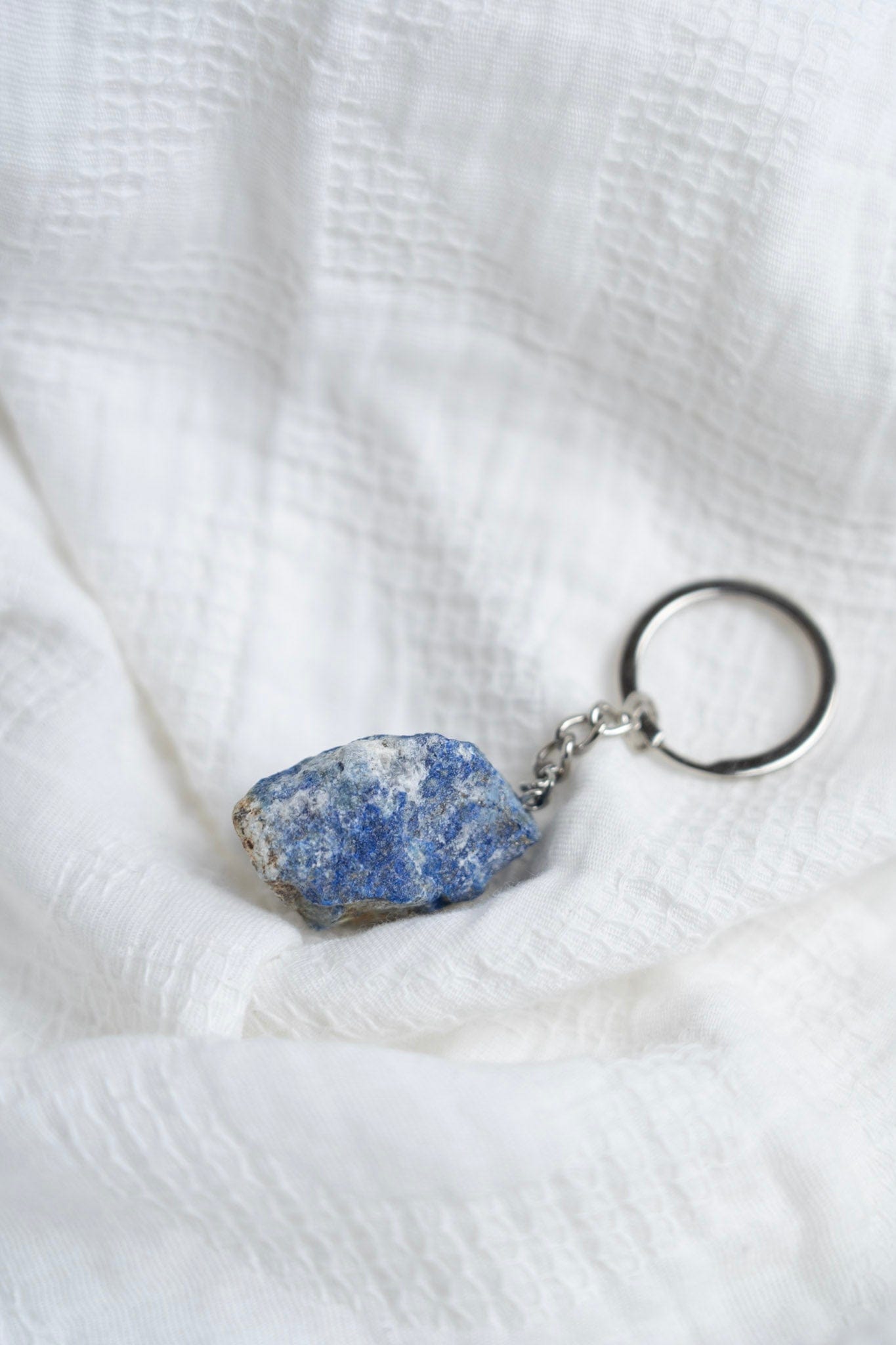 Keychain with a Labradorite stone pendant on a white fabric background