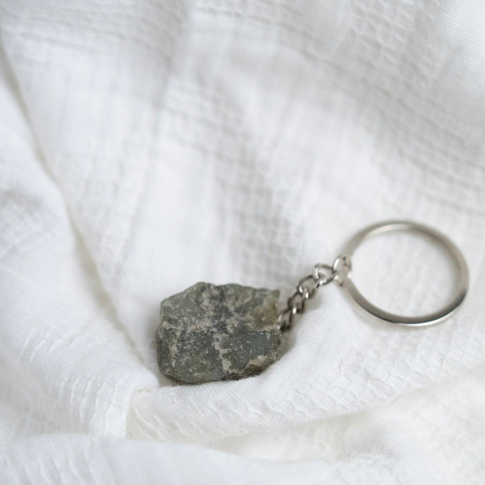 Keychain with a Labradorite charm on a white textured fabric background