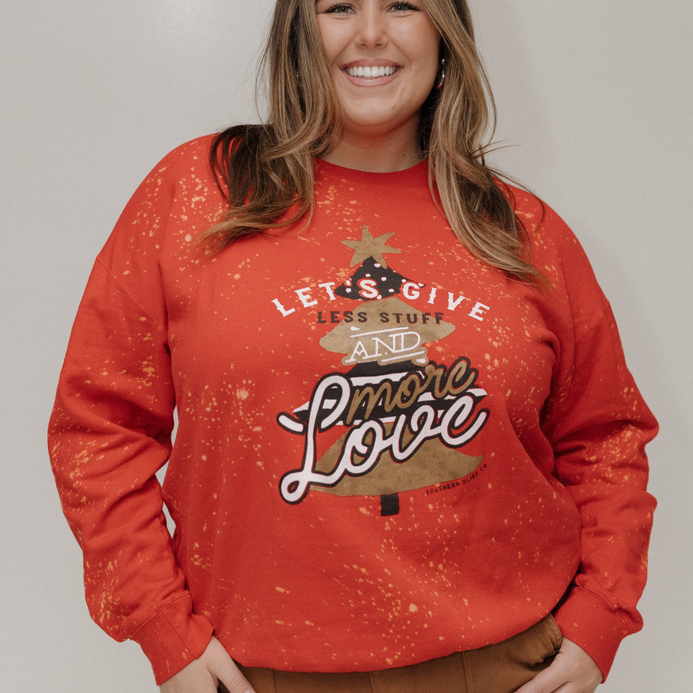 Woman wearing a red sweatshirt with a graphic design and text, standing against a plain background.