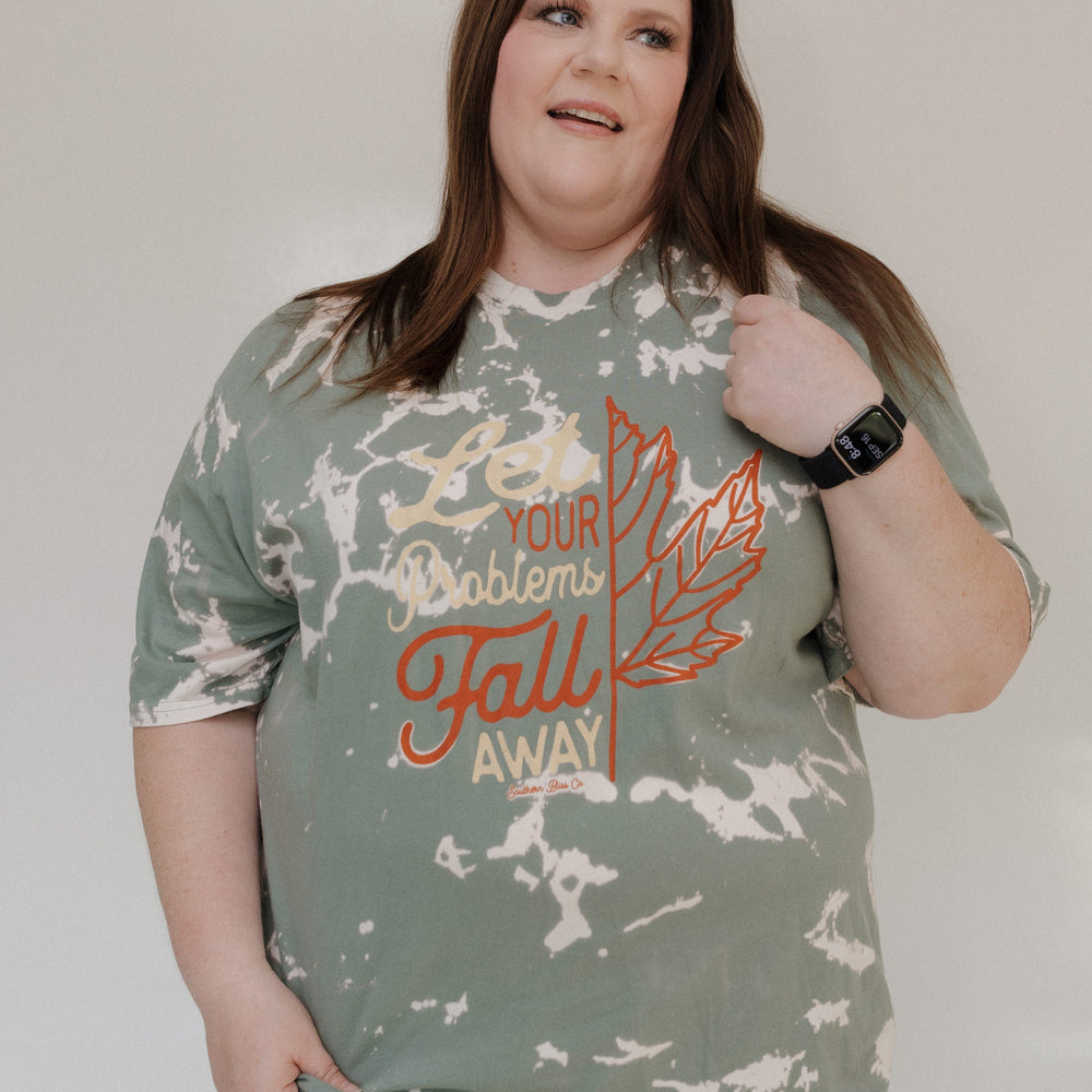 "LET YOUR PROBLEMS FALL AWAY" GRAPHIC TEE
A person beams in the Love Marlow "LET YOUR PROBLEMS FALL AWAY" graphic tee, featuring a leaf design and an inspirational message, perfect for fall fashion.
