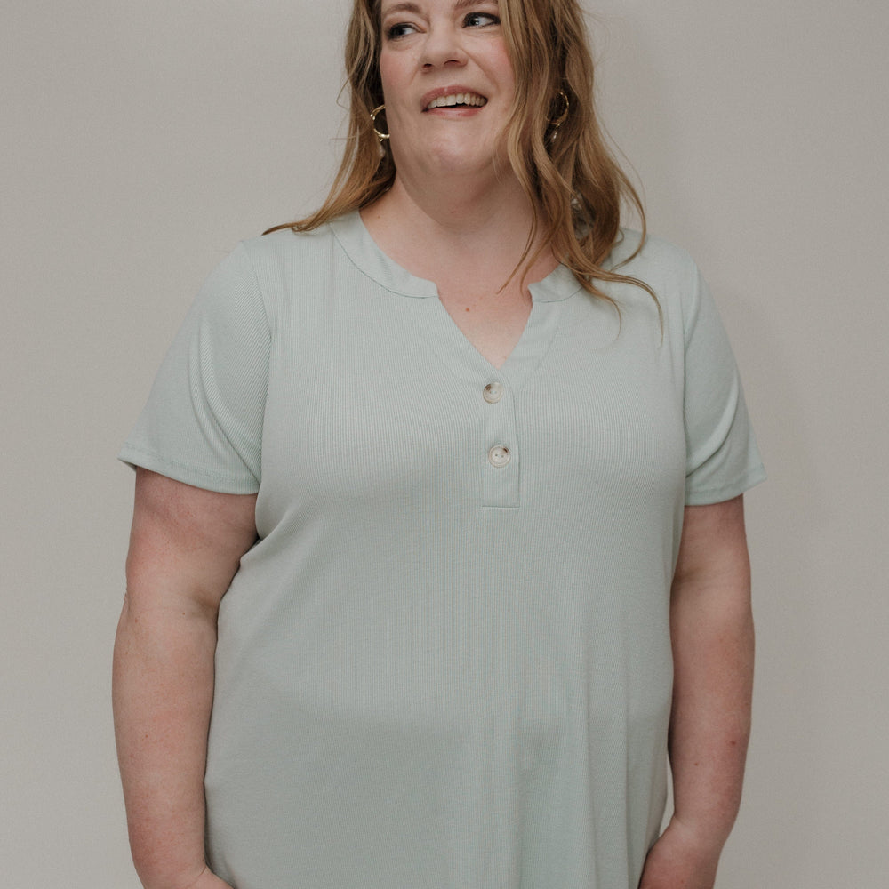 Woman wearing a light green shirt against a plain background