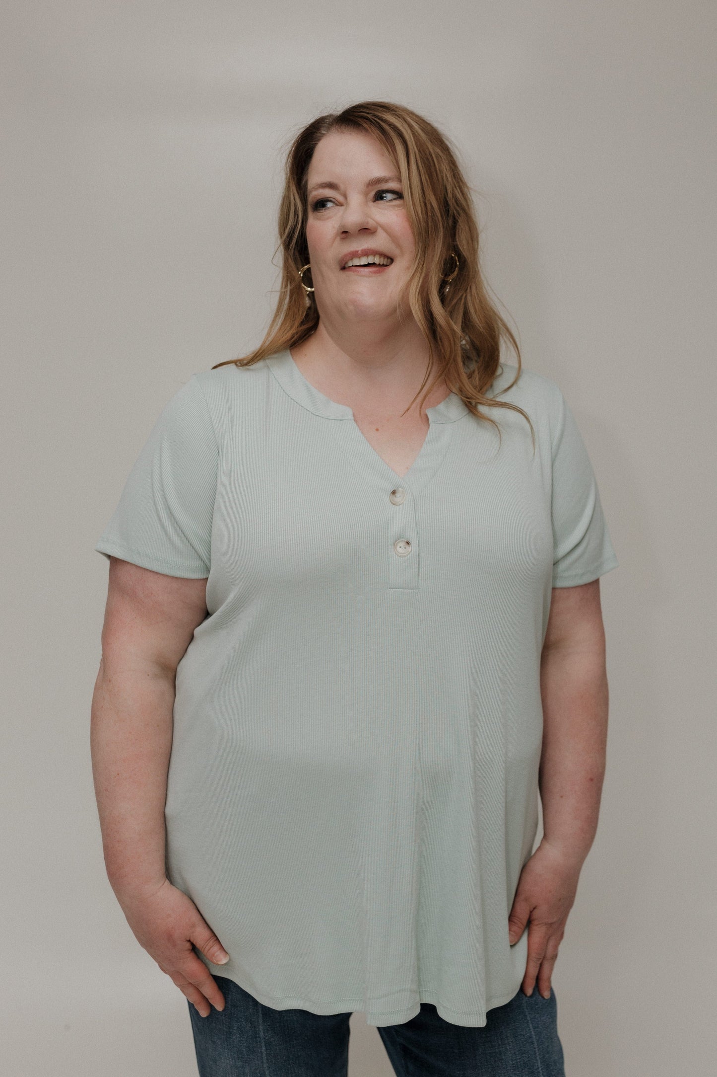 Woman wearing a light green shirt against a plain background