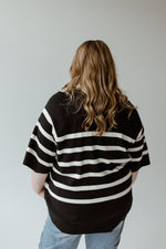 A woman wearing the Yesta Lightweight Stripe Sweater in black and ecru, featuring an elegant round neckline, exudes effortless sophistication.