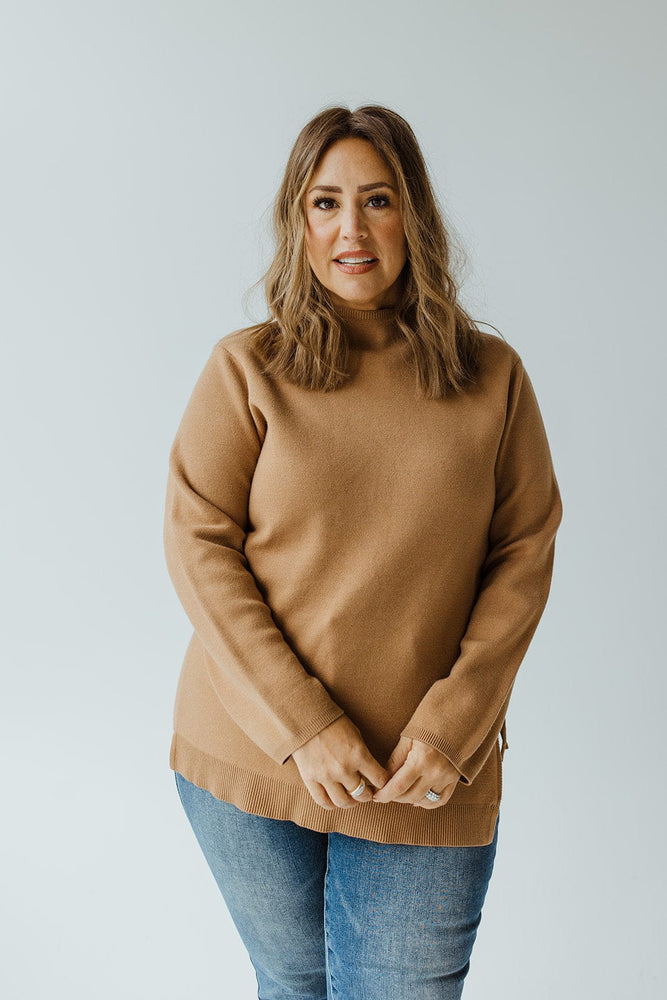 A person with long, light brown hair is wearing the Yesta Lightweight Sweater with Zipper Detail in Dark Camel and blue jeans, seen from the back against a plain background.