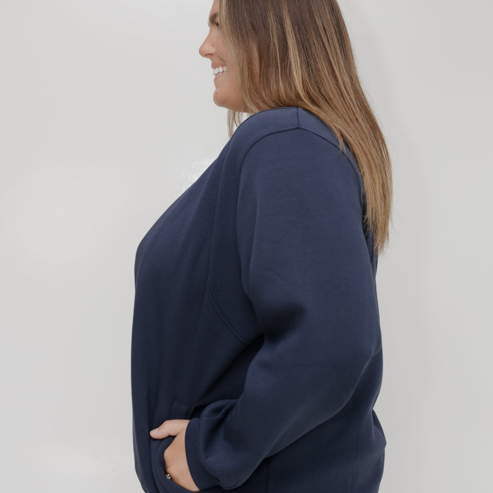 Woman wearing a navy blue sweatshirt against a white background