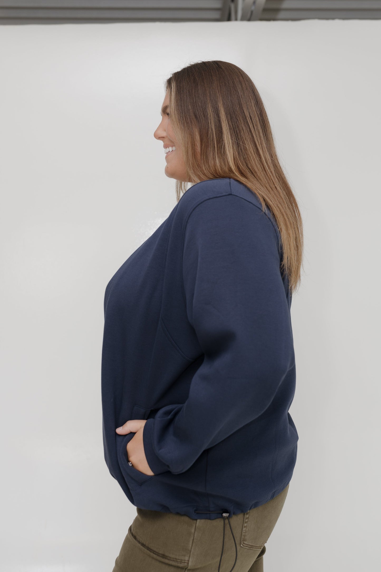 Woman wearing a navy blue sweatshirt against a white background