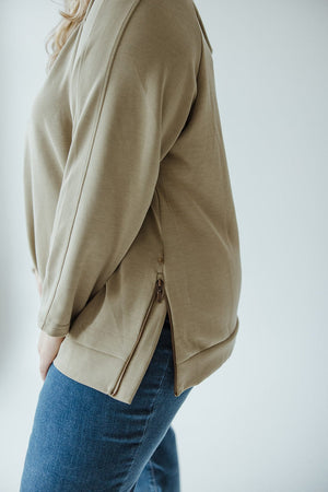 Person wearing an OM Green LIGHT AS AIR DOUBLE-STRING HOODIE by Yesta and blue jeans, embodying contemporary leisurewear against a light background.