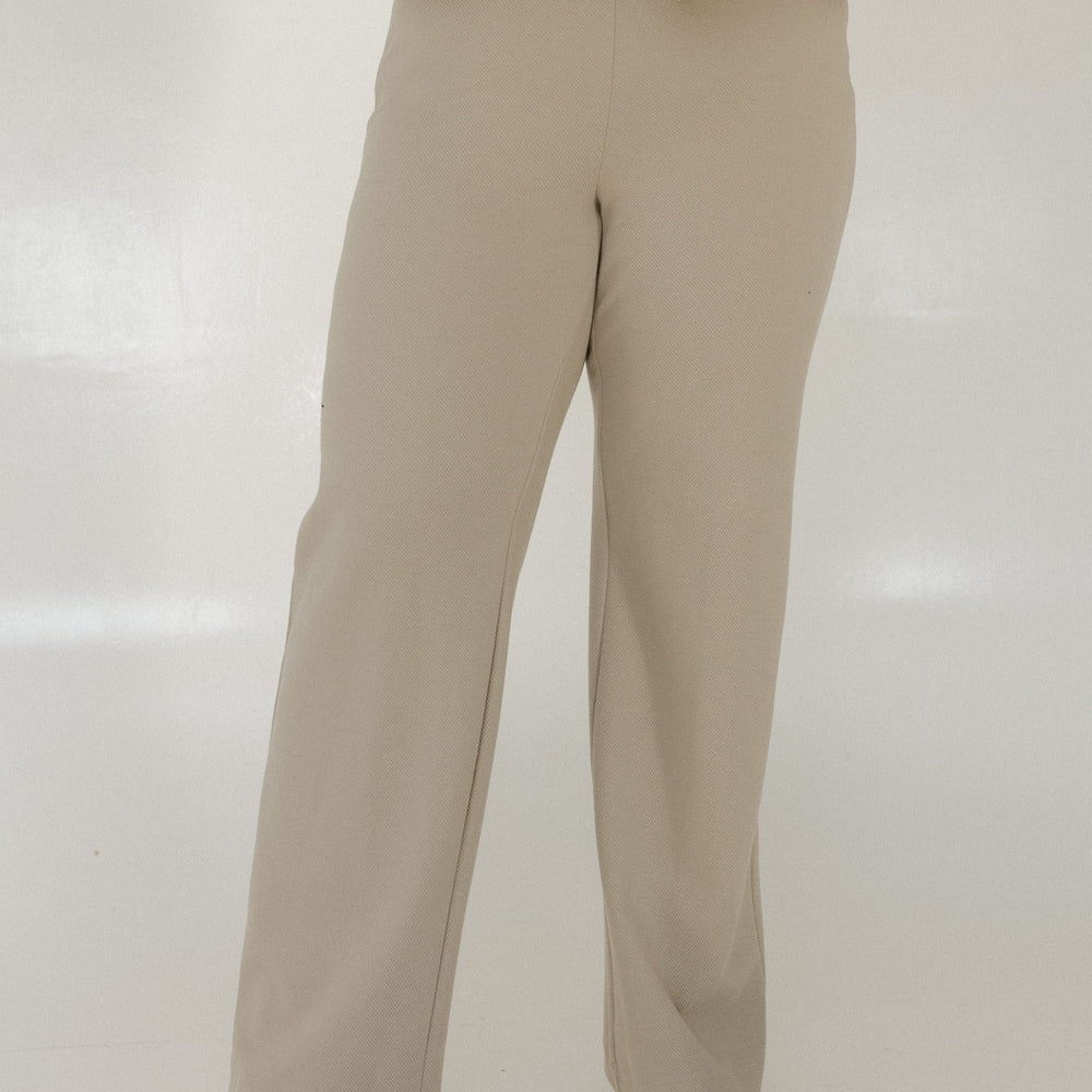 Person wearing a beige outfit on a white background