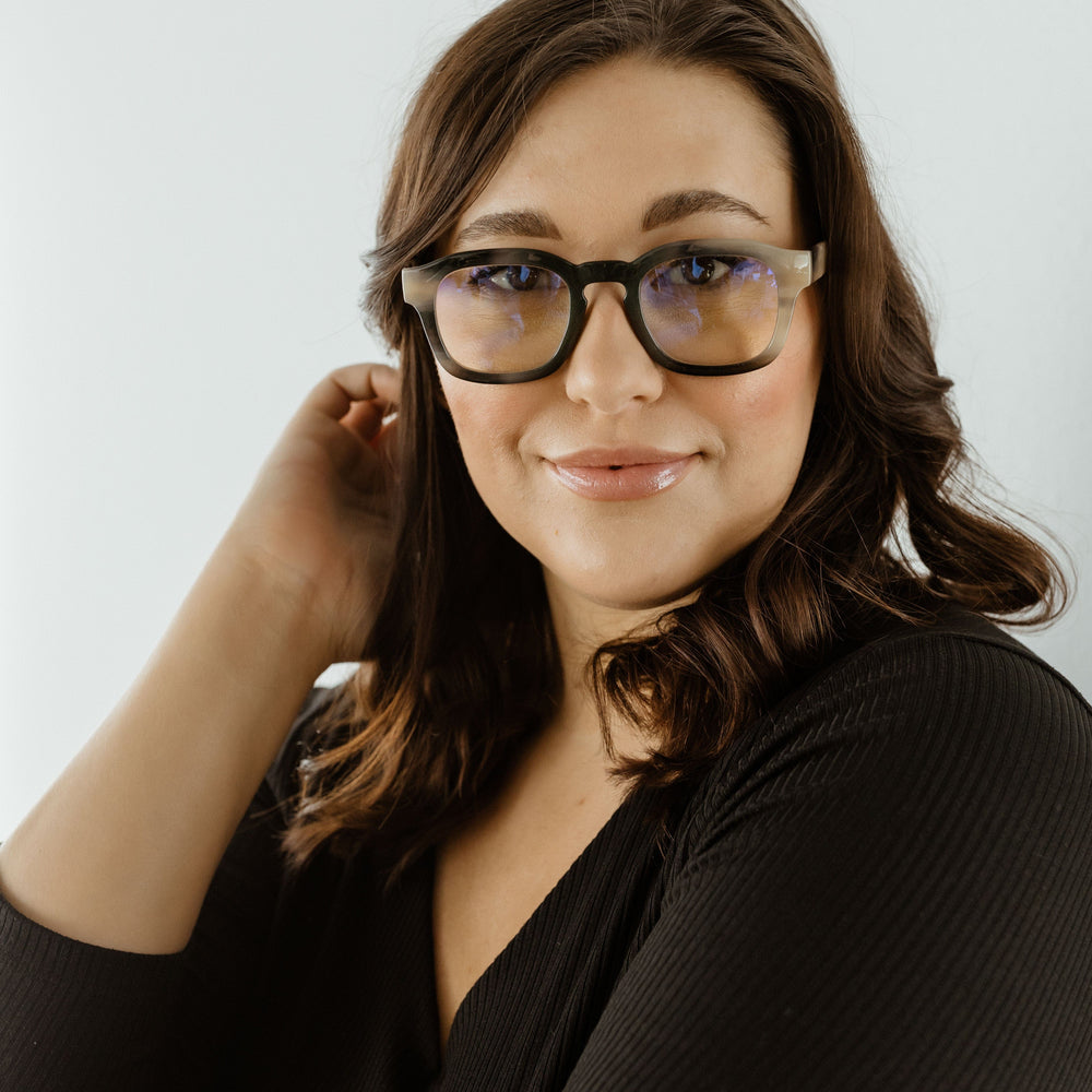 Woman wearing glasses with a plain white background