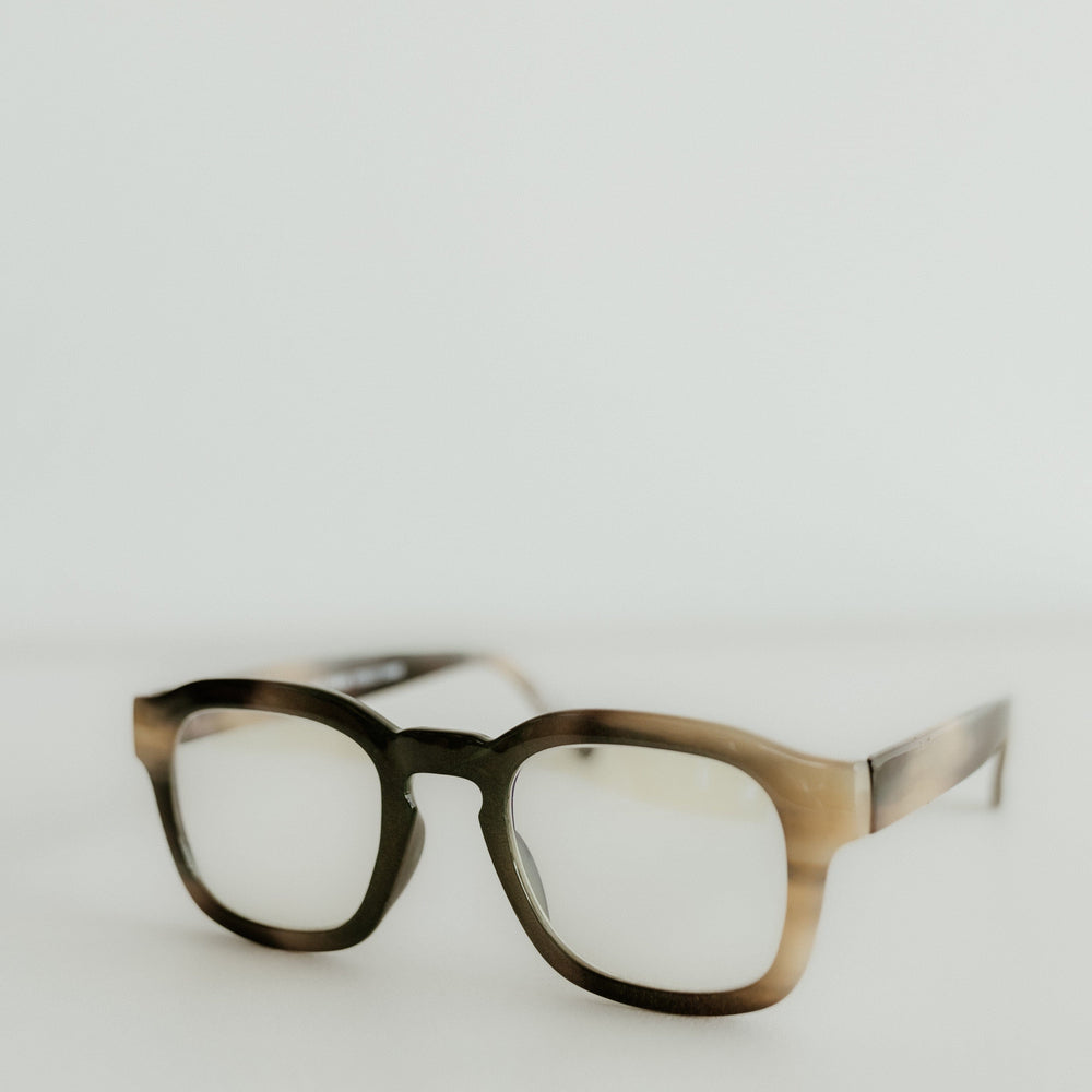 Pair of glasses with a tortoiseshell frame on a light gray background