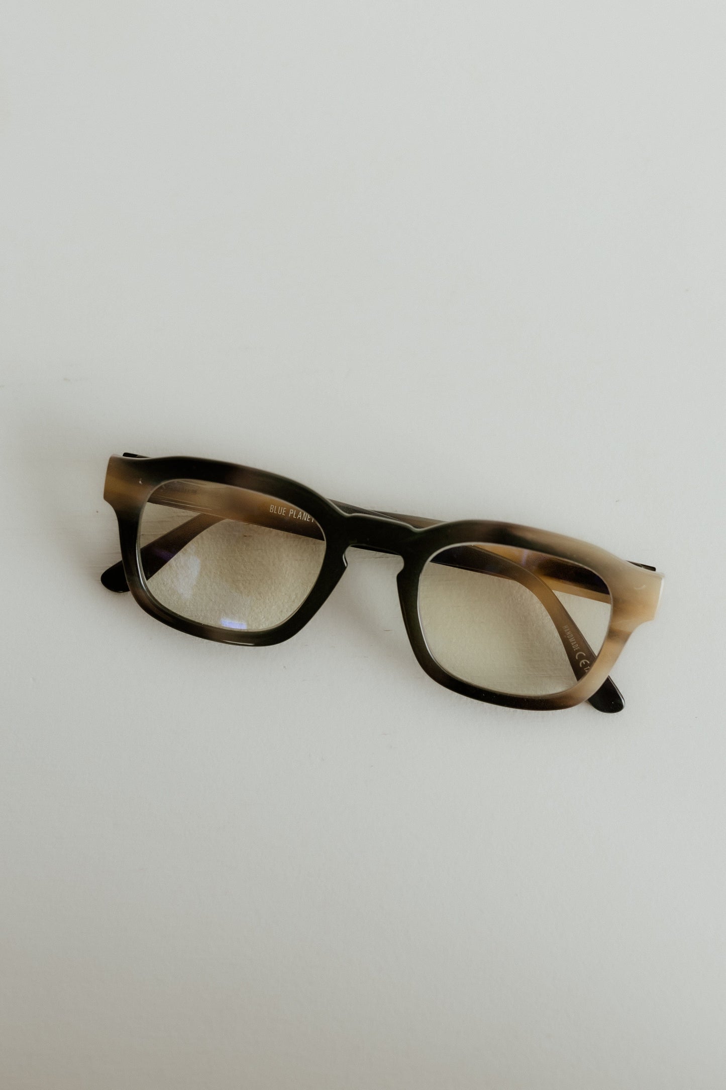 Pair of glasses with tortoiseshell frame on a light gray background