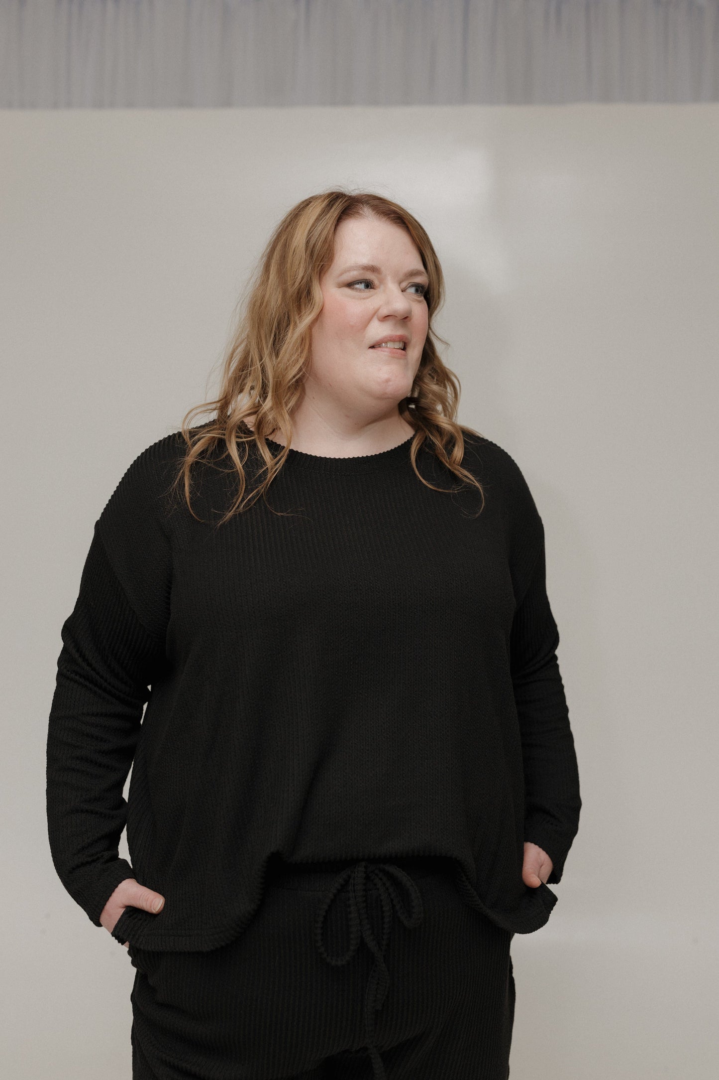 Person wearing a black outfit against a plain background
