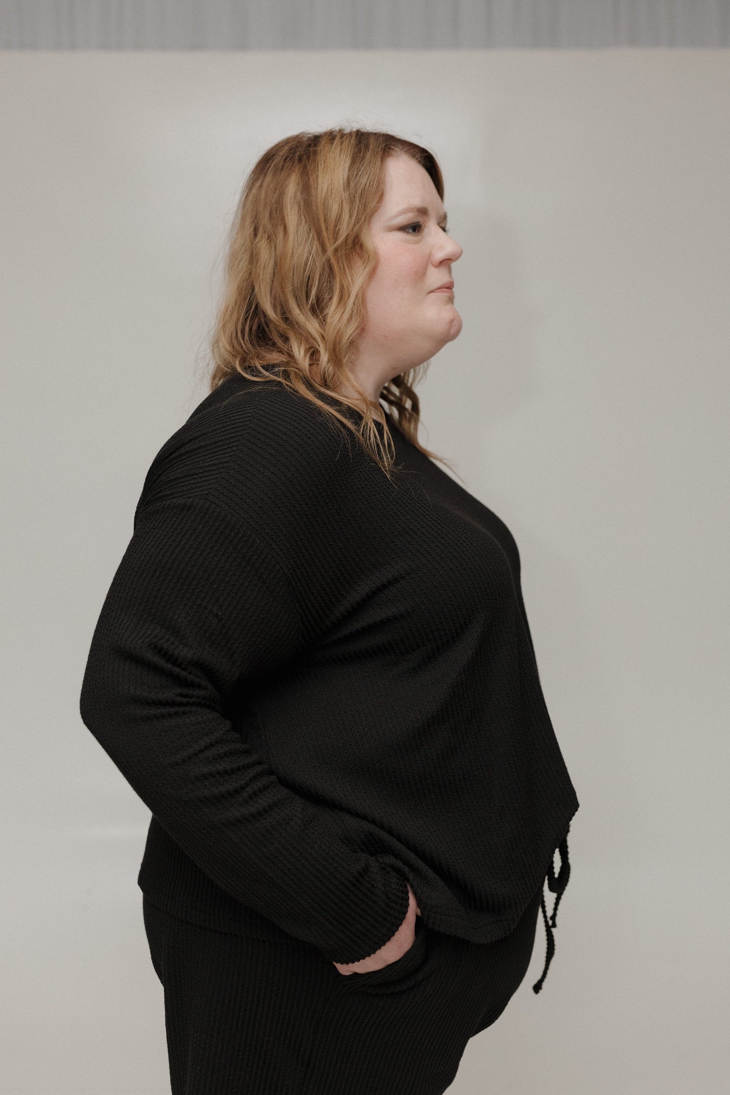 Person wearing a black outfit against a plain background