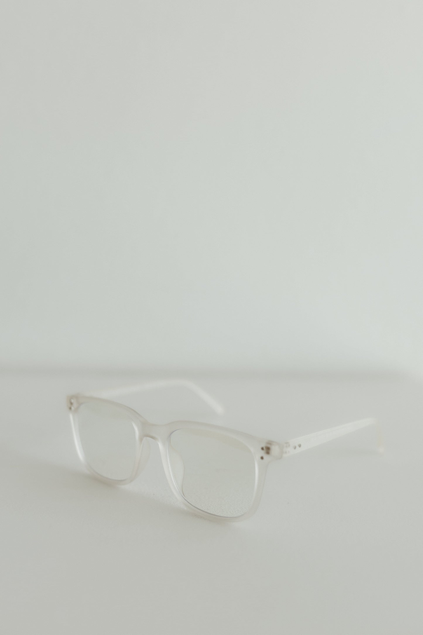 Clear eyeglasses on a light gray background