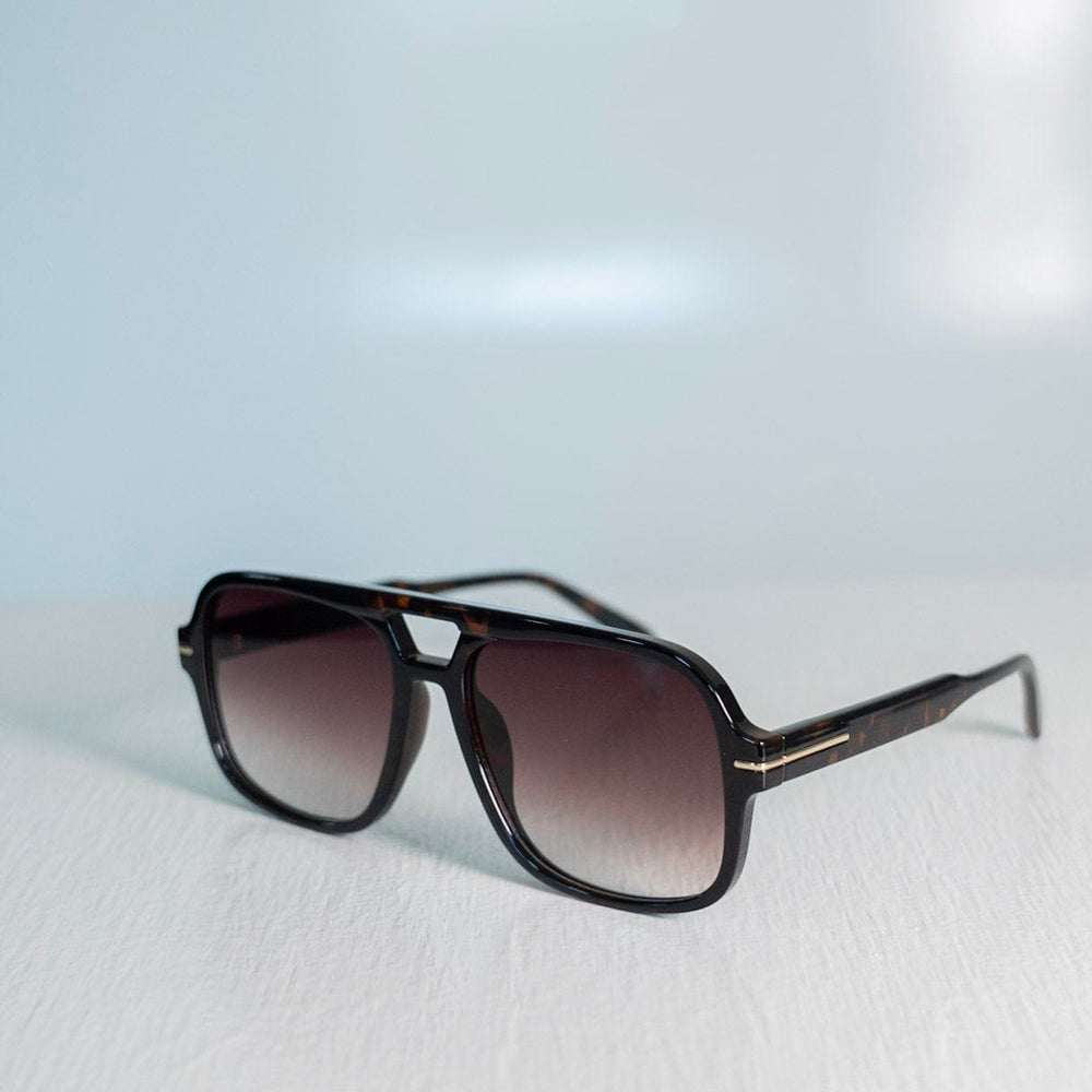 Sunglasses with a gradient lens on a light gray background