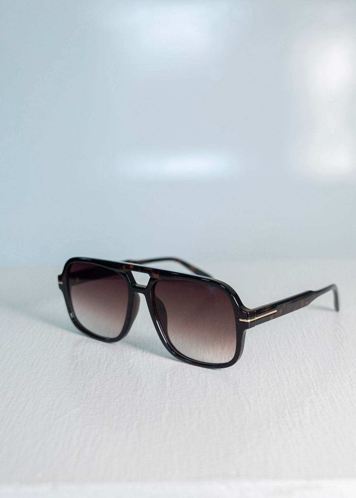 Sunglasses with a gradient lens on a light gray background