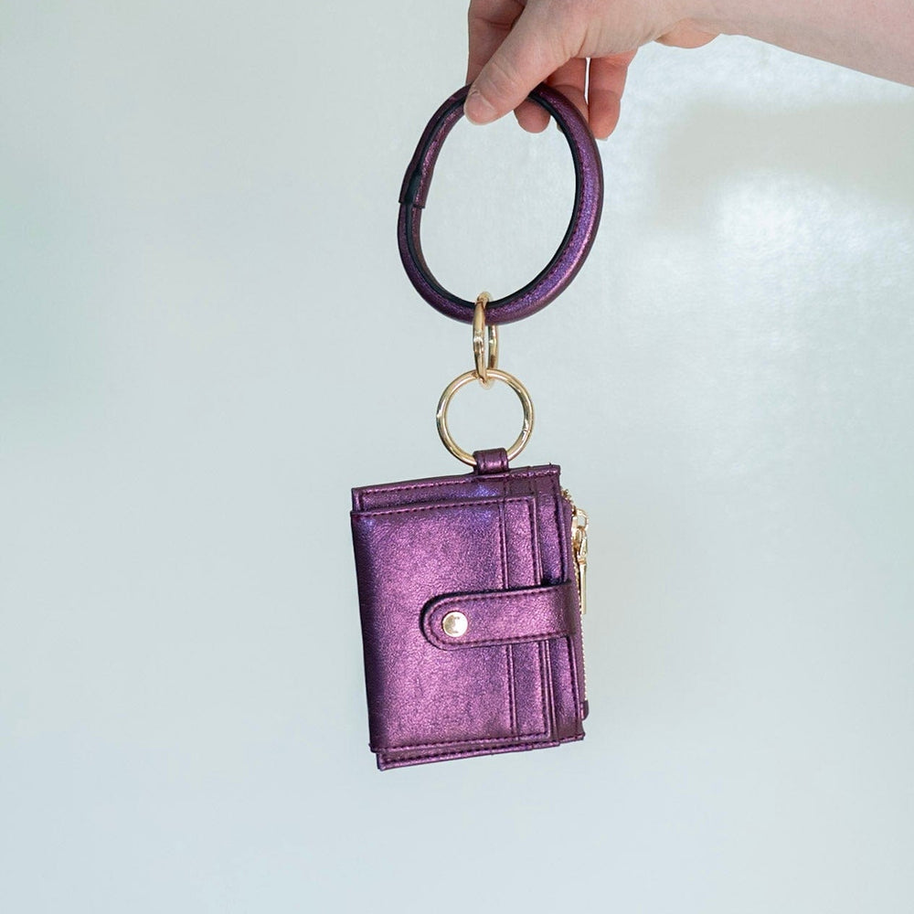 Show off your style with this metallic bangle wristlet wallet. Fold out the wallet to access your cards and IDs in secure snap closure — saving you from the rummage. Zip up your change pocket for a chic, sophisticated finish. Throw it on your wrist for easy access with an amethyst accent!