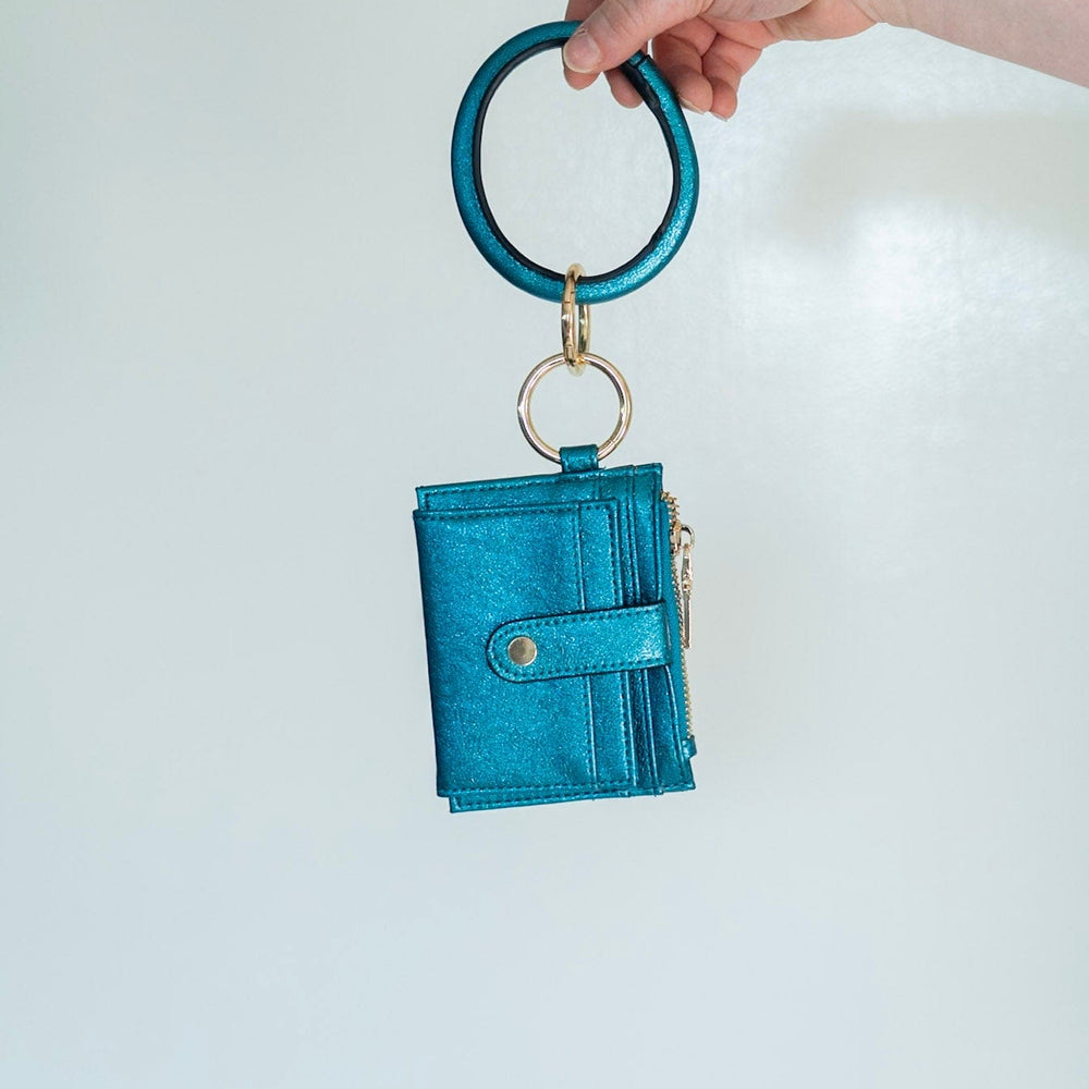 Make a bold statement with this METALLIC BANGLE WRISTLET WALLET IN MALACHITE! Its fold-out wallet design, snap closure, card slots, and zip change pocket provide all the functionality you need for running around town. Who says you can't look stylish while staying organized? This wallet does it all!