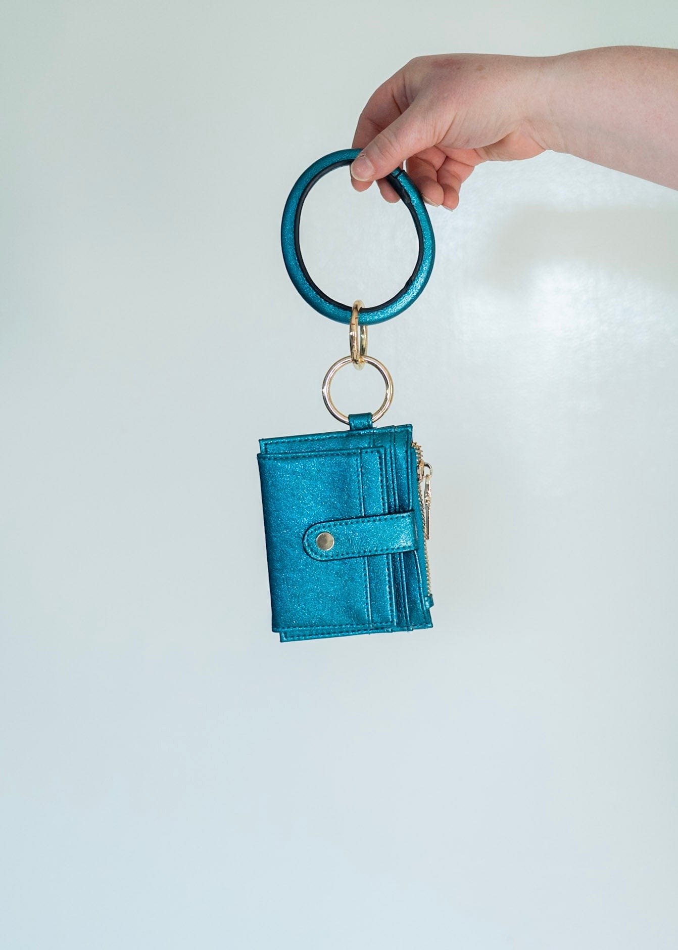 Make a bold statement with this METALLIC BANGLE WRISTLET WALLET IN MALACHITE! Its fold-out wallet design, snap closure, card slots, and zip change pocket provide all the functionality you need for running around town. Who says you can't look stylish while staying organized? This wallet does it all!