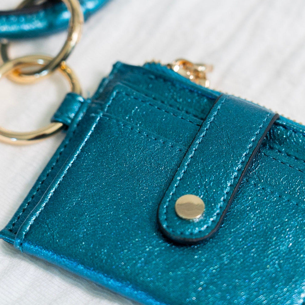 Make a bold statement with this METALLIC BANGLE WRISTLET WALLET IN MALACHITE! Its fold-out wallet design, snap closure, card slots, and zip change pocket provide all the functionality you need for running around town. Who says you can't look stylish while staying organized? This wallet does it all!