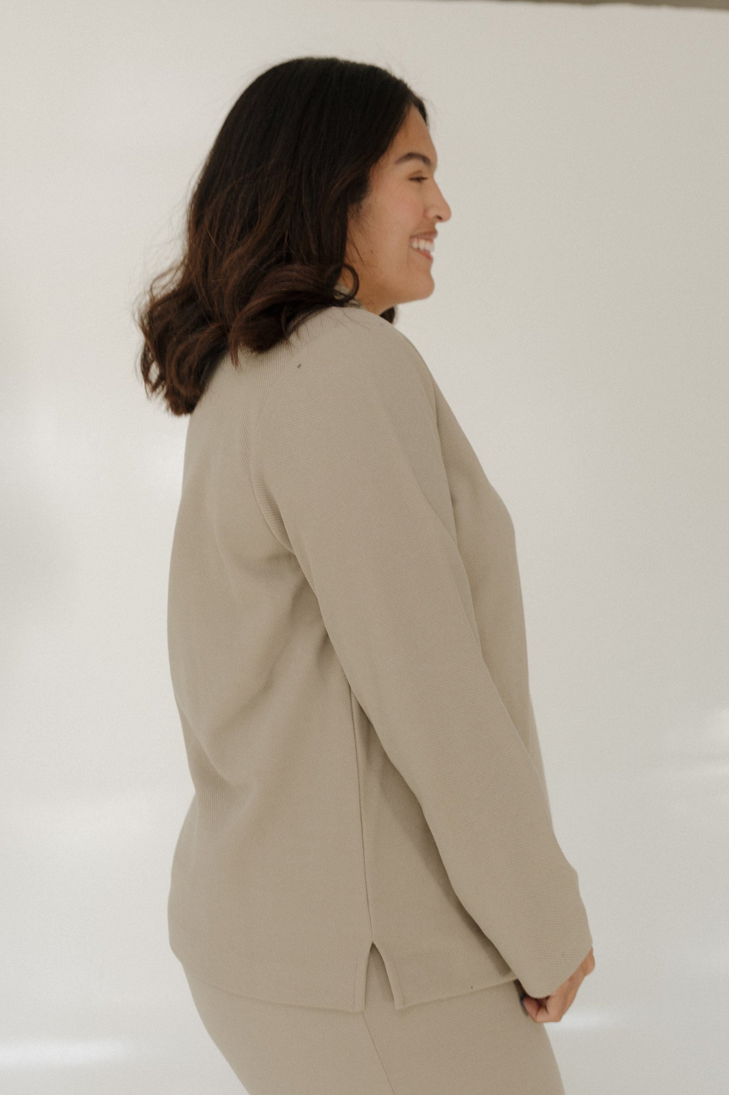 Woman wearing a beige blazer against a white background