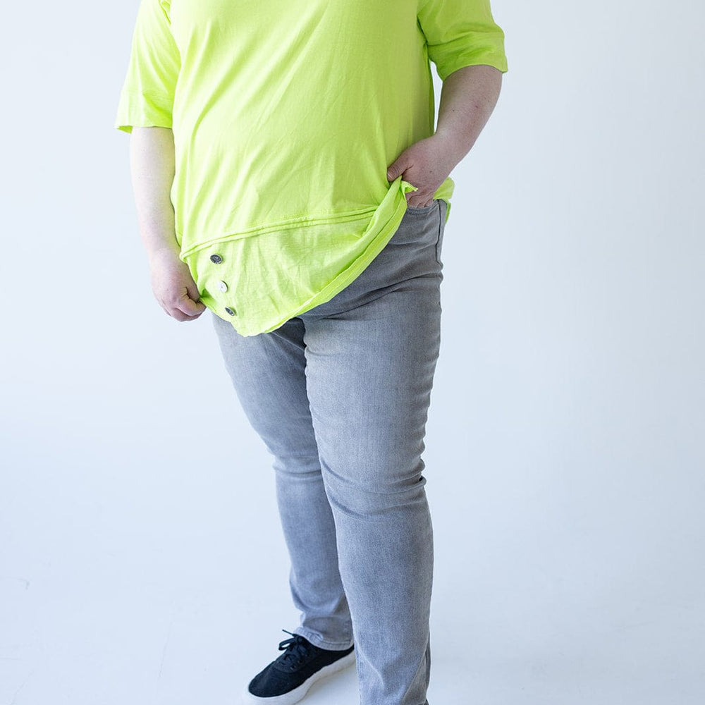 Person wearing a bright yellow shirt, Love Marlow's MID-RISE SKINNY JEAN WITH ZIPPER DETAIL IN LIGHT GREY, and black shoes stands against a plain background with one hand in their pocket.