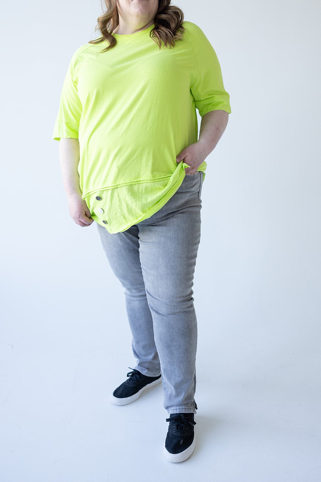 Person wearing a bright yellow shirt, Love Marlow's MID-RISE SKINNY JEAN WITH ZIPPER DETAIL IN LIGHT GREY, and black shoes stands against a plain background with one hand in their pocket.