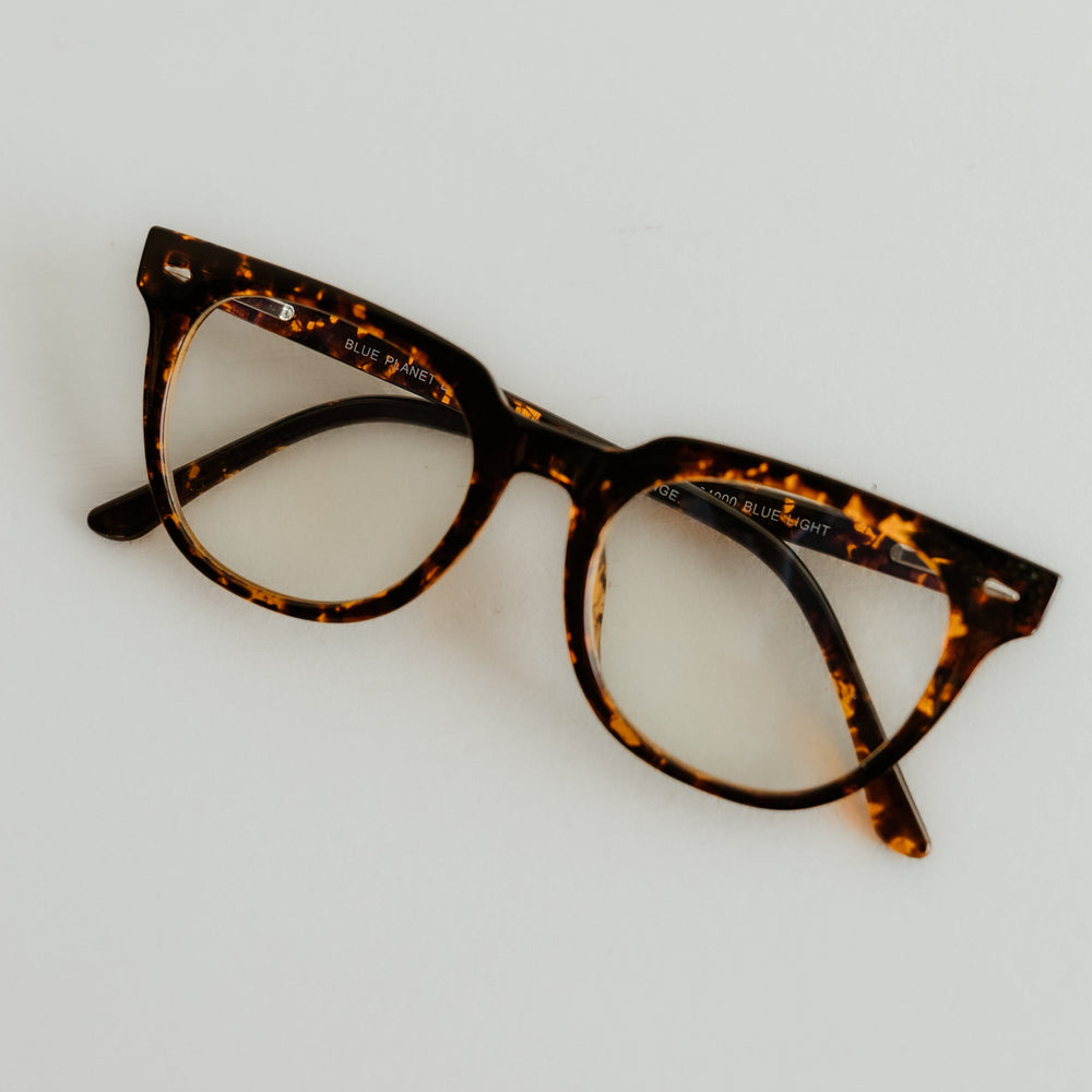 Tortoiseshell cat-eye glasses on a light gray background