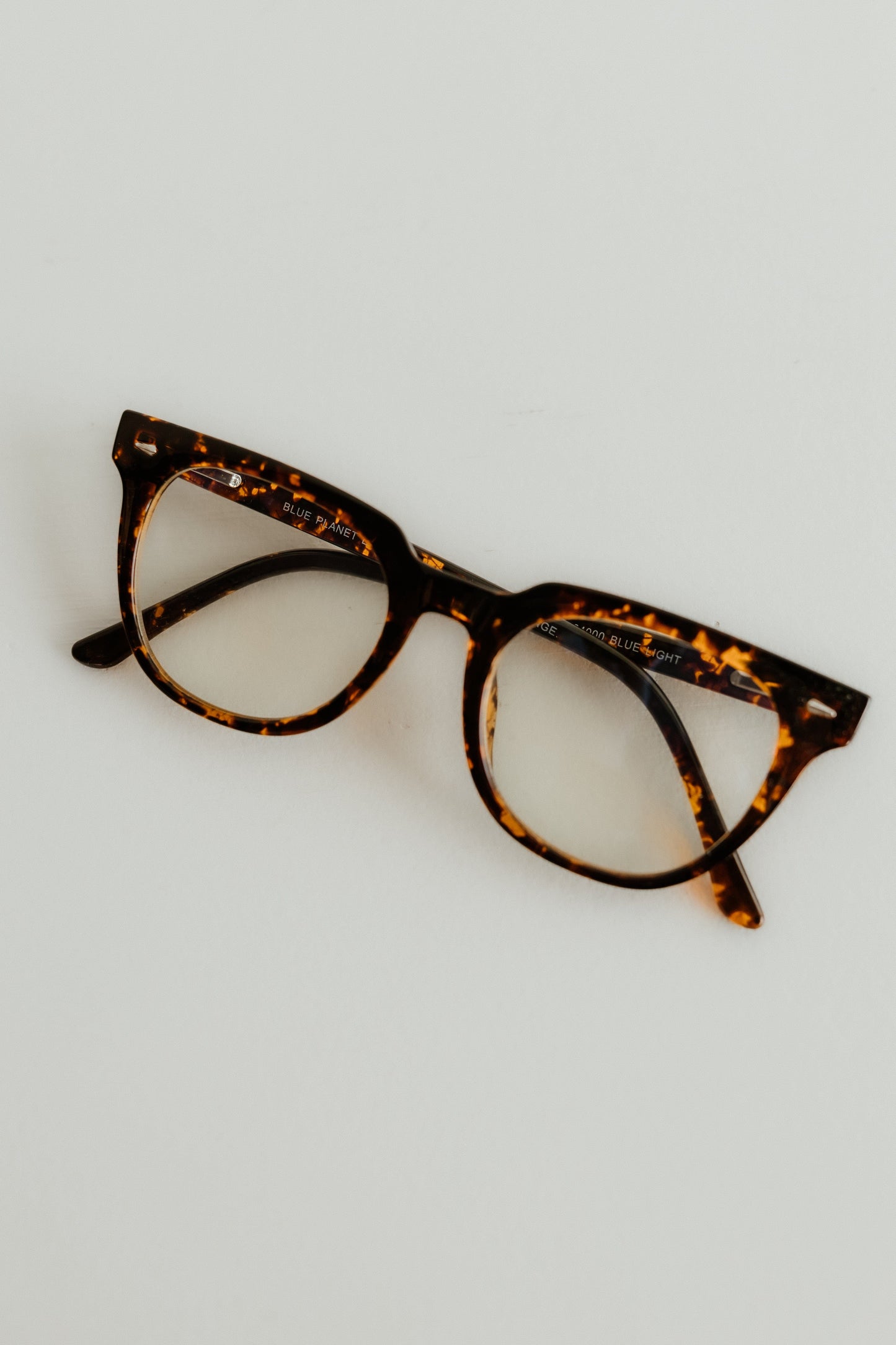 Tortoiseshell cat-eye glasses on a light gray background