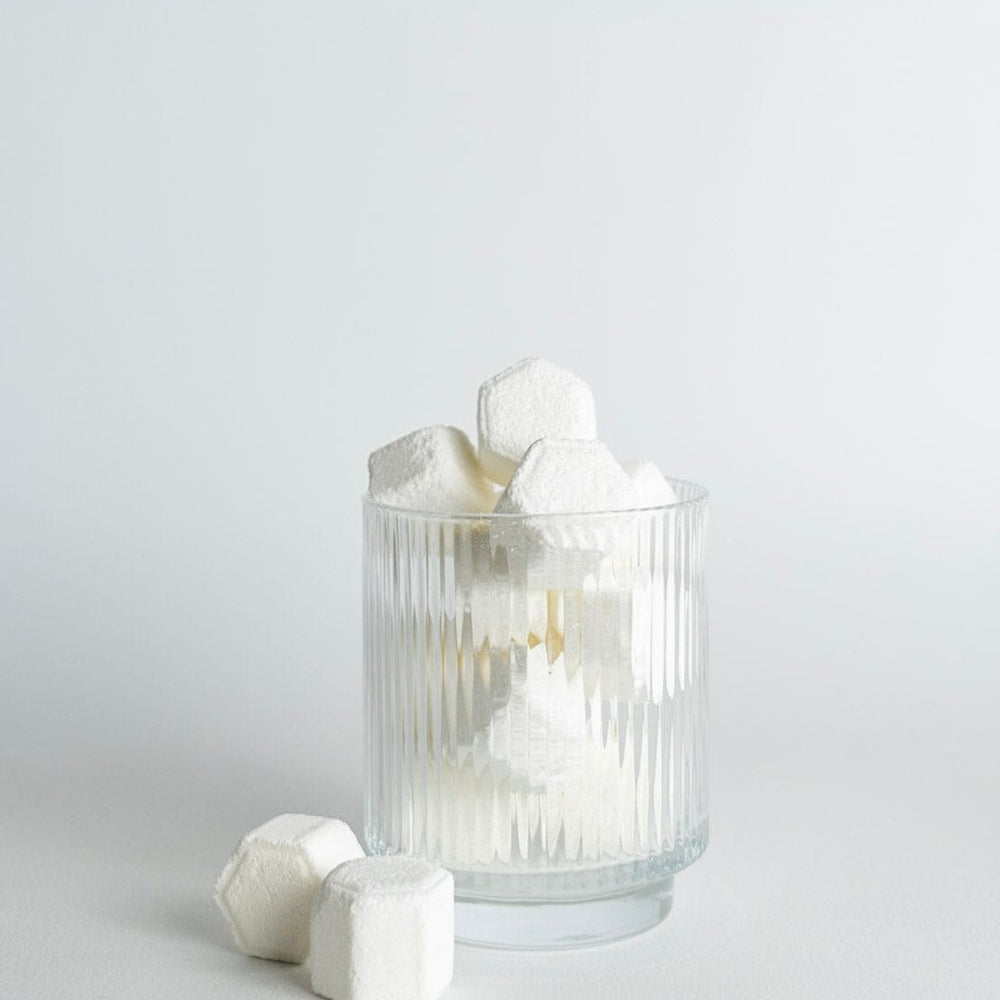 Clear glass with shower steamers on a light gray background