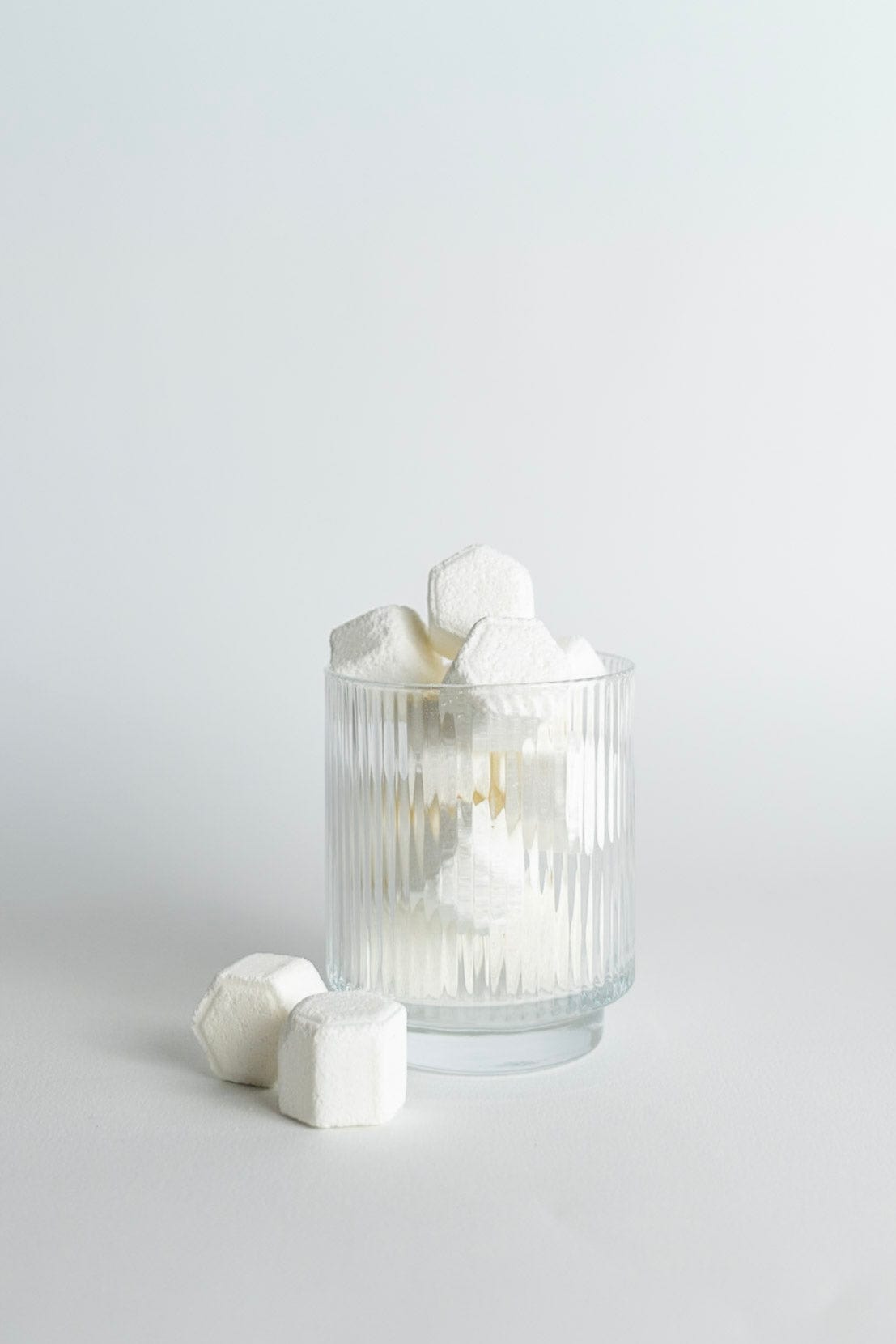 Clear glass with shower steamers on a light gray background