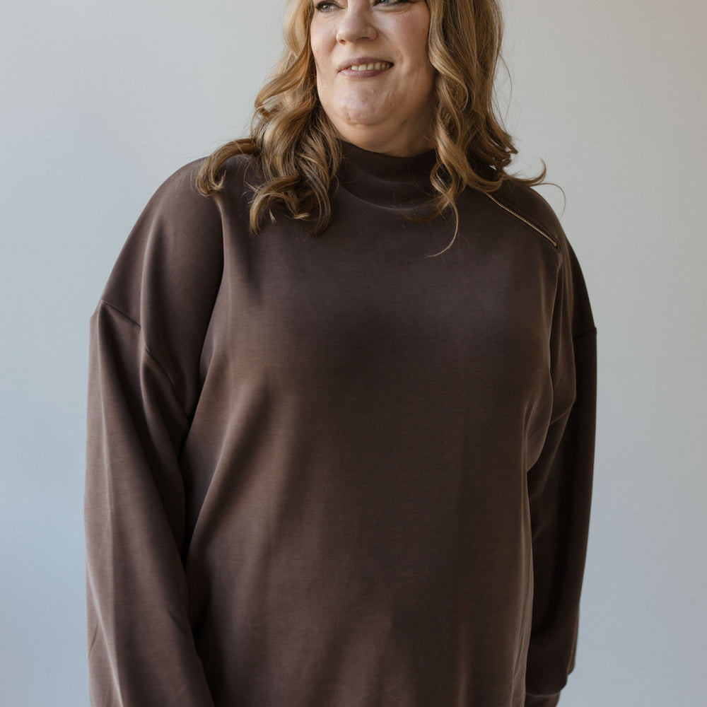 A person wearing the Yesta Mock Turtleneck Zipper Detail Blouse stands in front of a plain background, effortlessly paired with jeans.