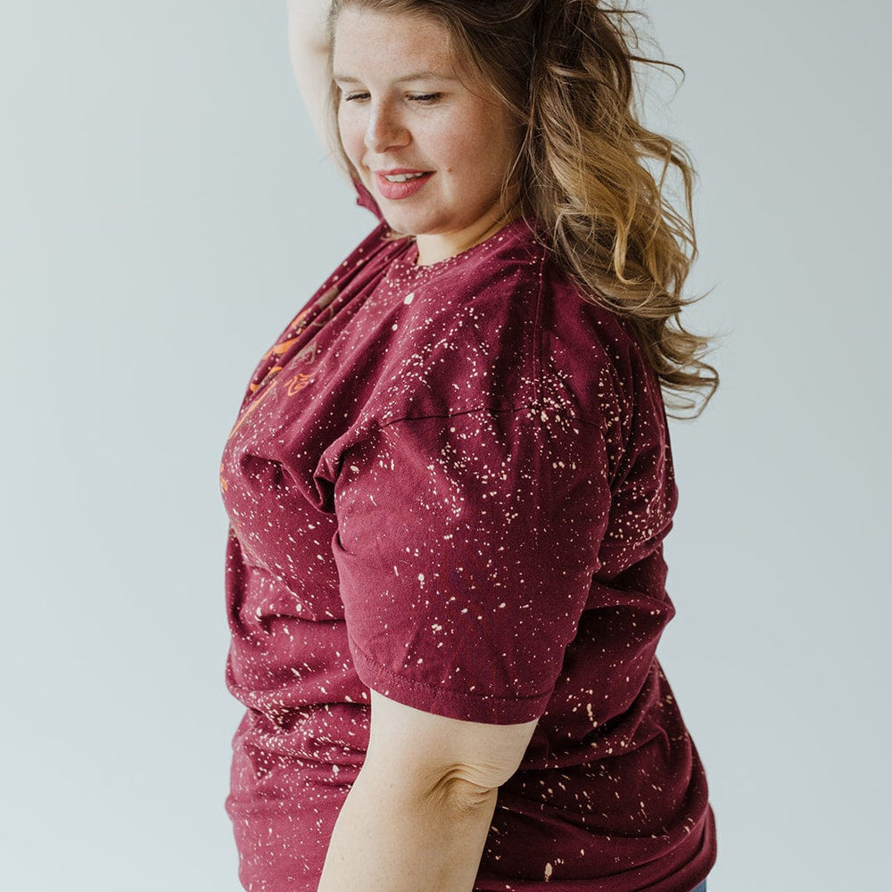 A person wearing the "MORE SPICE THAN PUMPKIN" graphic tee by Southern Bliss and jeans poses with one hand on their head against a light background.