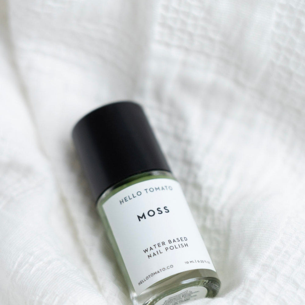 Moss water-based nail polish bottle on a white textured background