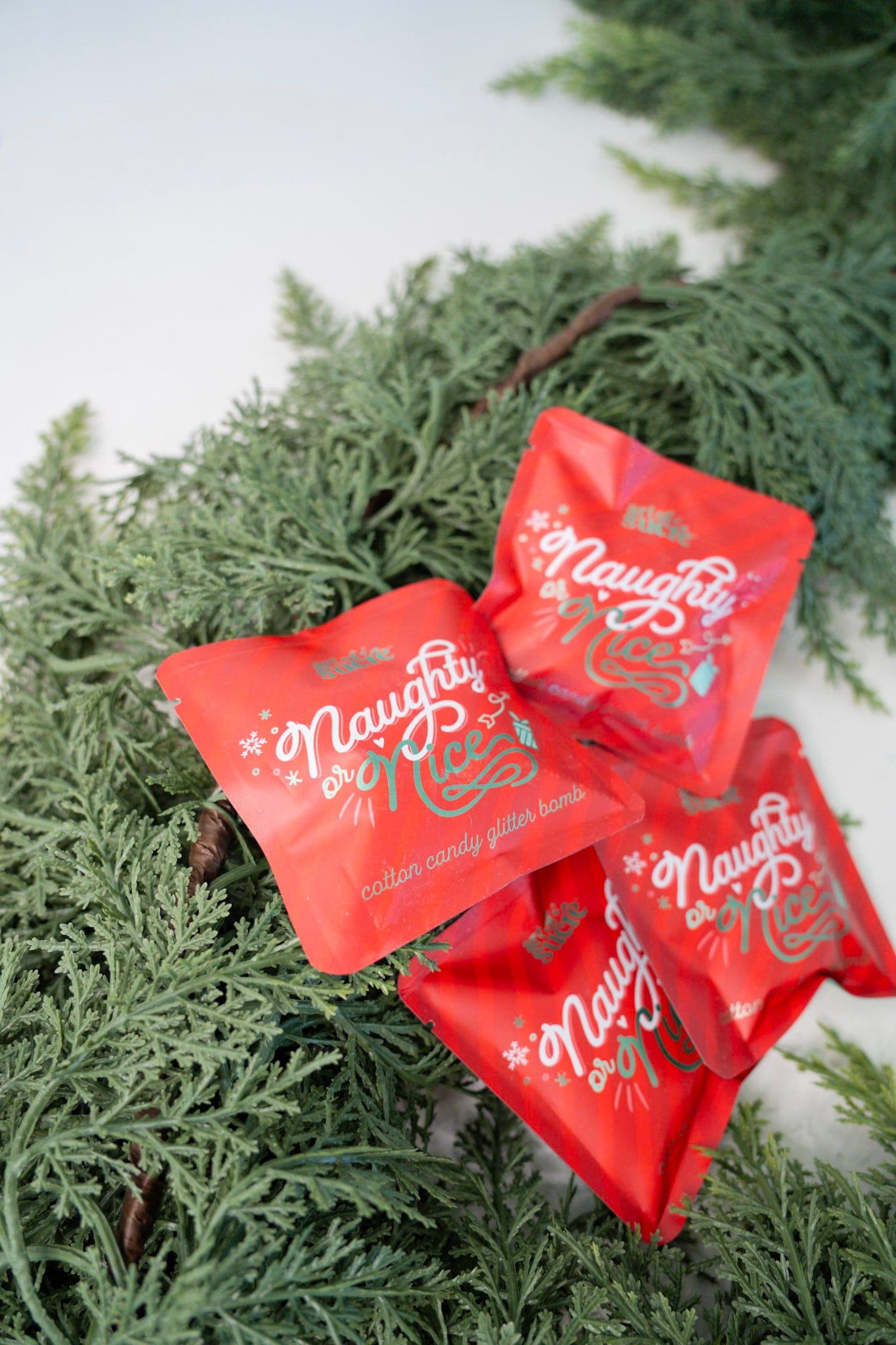 Red 'Naughty or Nice' packages on a green wreath