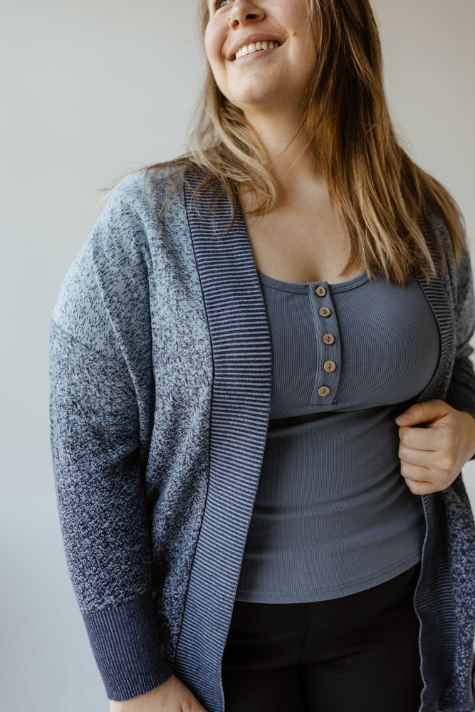 A woman wearing an Ombre Textured Cardigan with Striped Collar Detail by Yesta, paired with a tank top.