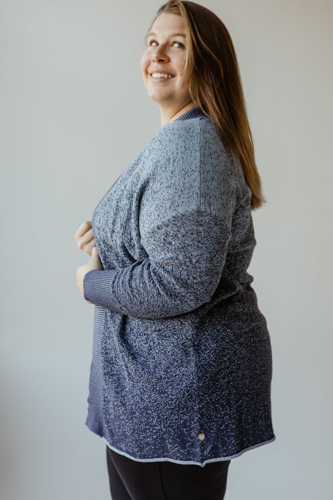 A woman wearing a lightweight cardigan featuring an ombre texture and striped collar detail by Yesta.