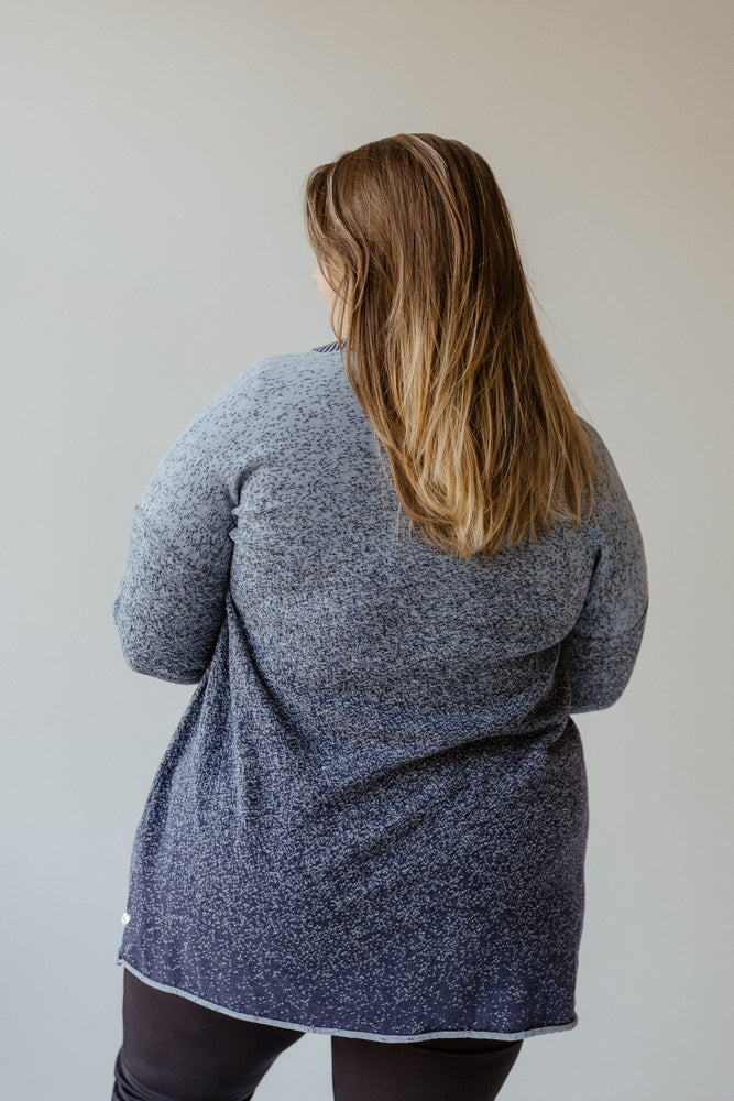 A woman with long hair elegantly complements her stylish work wardrobe with the OMBRE TEXTURED CARDIGAN WITH STRIPED COLLAR DETAIL by Yesta.