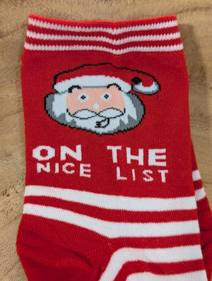 Cozy holiday sock featuring Santa's cheerful face and the text "ON THE NICE LIST" in crisp white letters.