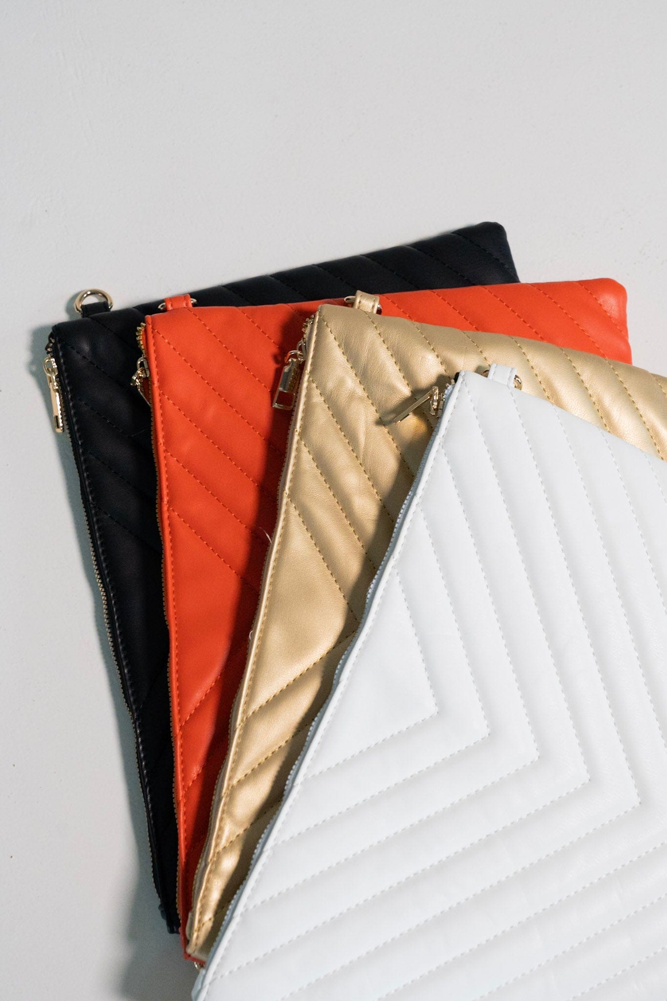 Set of quilted pouches in black, red, gold, and white on a light gray background
