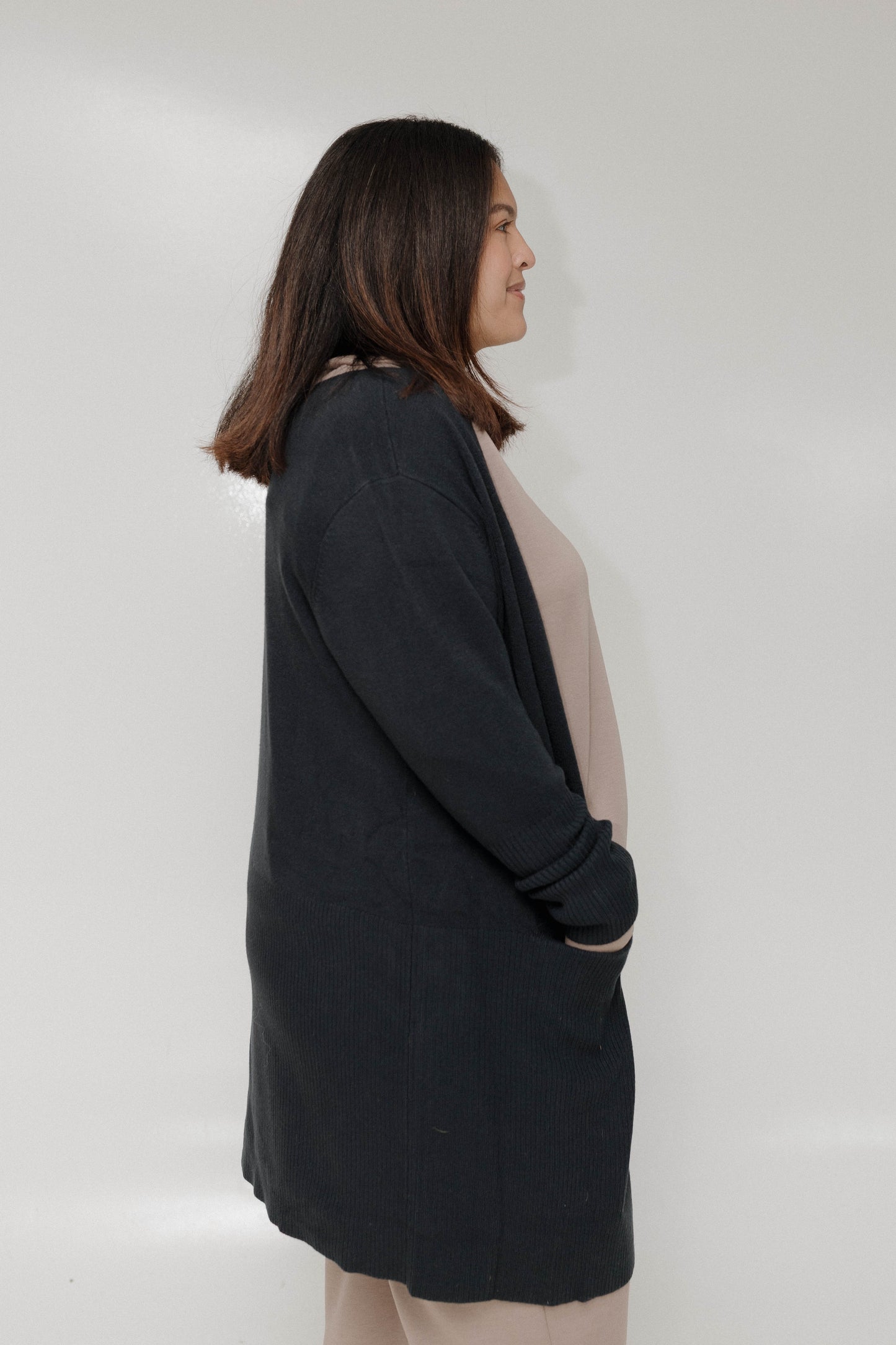 Person wearing a black cardigan against a white background