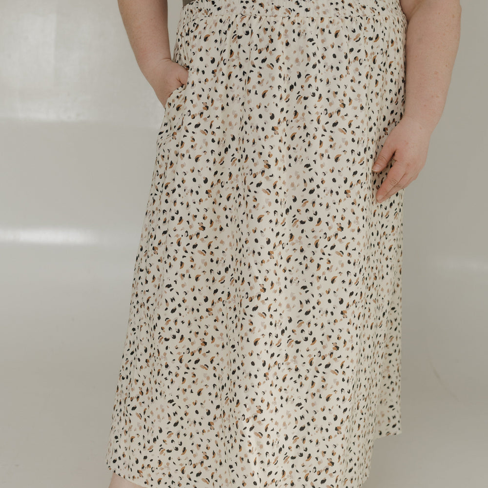 Person wearing a floral skirt and green top on a plain background