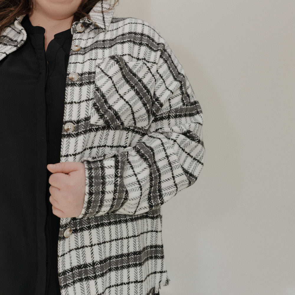 Person wearing a black and white striped scarf against a plain background
