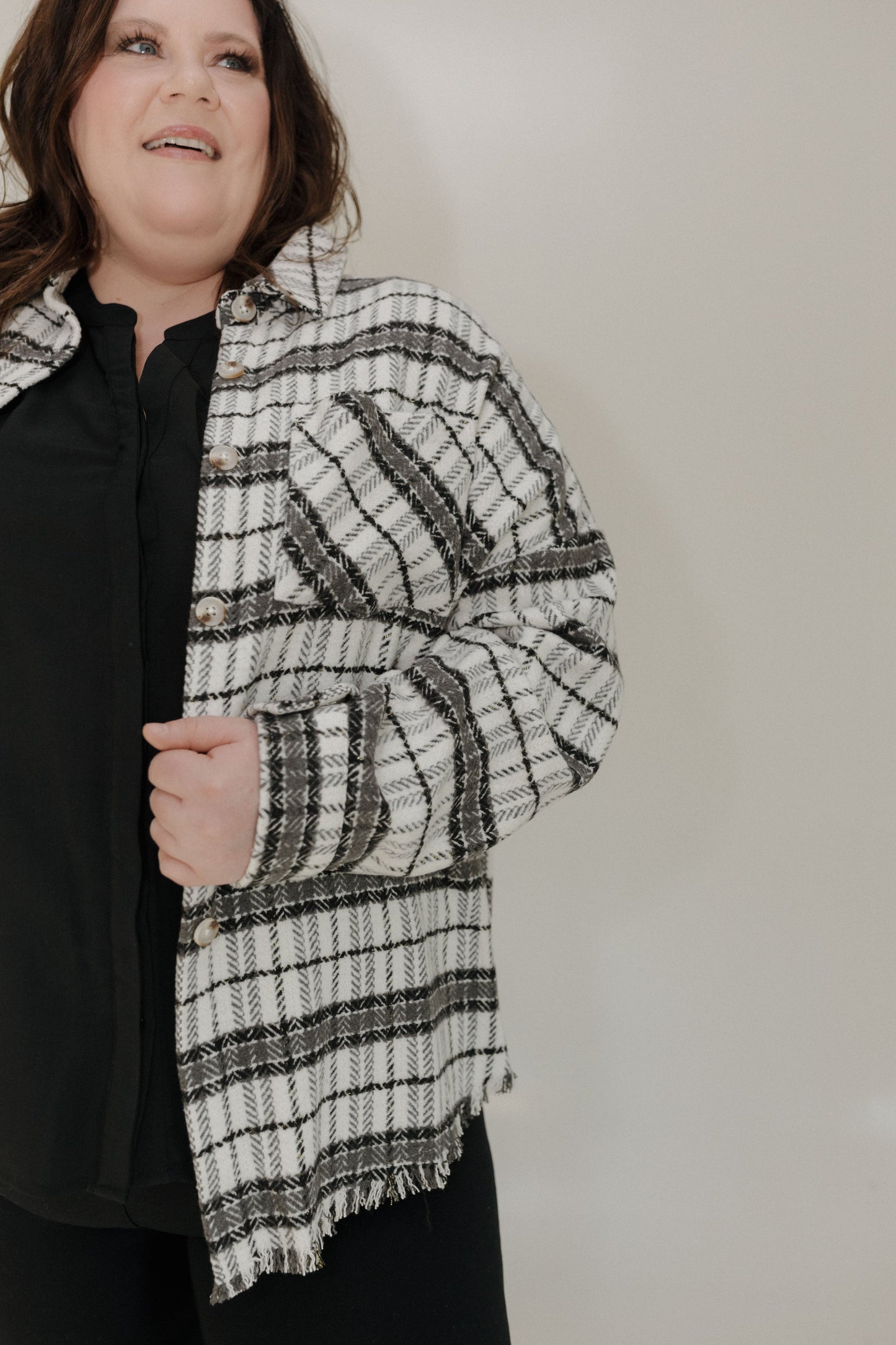 Person wearing a black and white striped scarf against a plain background